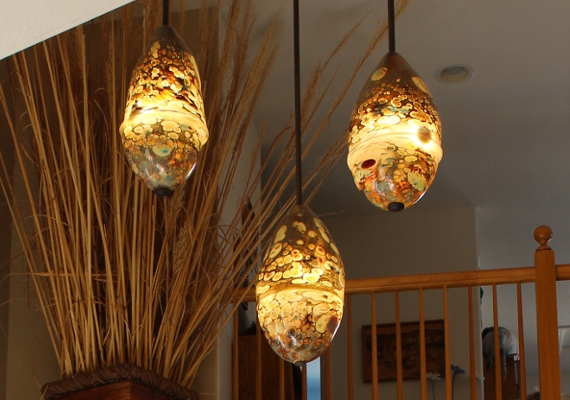 This is a commissioned group for a foyer
											in Centennial, CO.  The homeowner wanted something notably 
											unique, yet nature-related.  She and I arrived at this concept 
											which creates a stunning and uplifting entrance to her family 
											home.  Each	pod is aprox. 22 x 12 in., and contains 6 l.e.d. 
											bulbs.