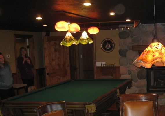 Moutains and Sunset Clouds hover whimsically over the 
											pool table in this game room, and a large Stone series shade 
											sets off the poker table creating a fun atmosphere for hosting 
											get togethers in this premier game room.