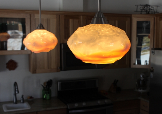 A pair of Sunset Clouds with just amber and white add 
											a great heart to this freshly built kitchen.  All the planning 
											and work done on the counters, cabinets and appliances comes to 
											life with the warm tones in the light shades.